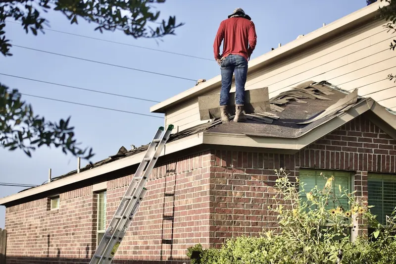 Professional roofer working on a residential roof in Asharoken